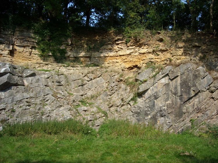 Photograph showing left-tilting limestone layers at the bottom then an angular unconformity, then horizontal oolitic limestone layers at the top.