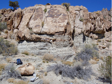 Animated GIF showing annotation of a photograph of Jurassic monzonite intruding into Cambrian sedimentary strata. A backpack serves as a sense of scale.