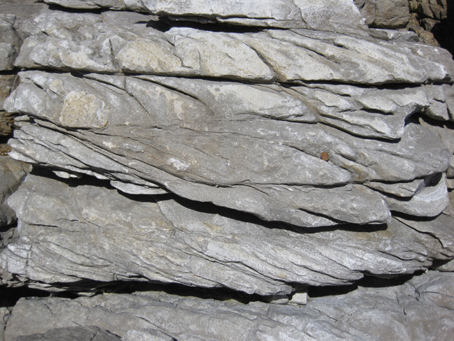 Animated GIF showing annotation of a photograph of up-side-down cross-bedding. 7 beds of quartzite are horizontal across the field of view. A penny serves as a sense of scale. The cross-beds are concave-DOWN, with truncated LOWER surfaces and tangential UPPER surfaces.
