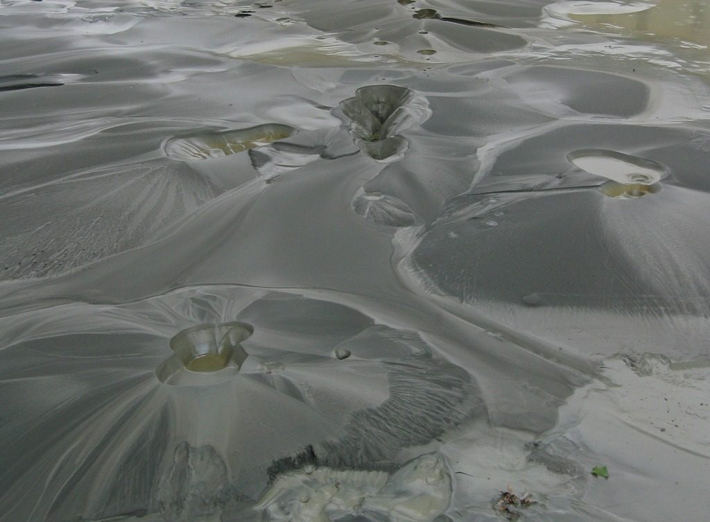 Photograph of sand volcanoes; mound of sand with a dip in the middle of the mound, from which the sand eruption originated.